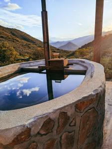 una piscina d'acqua in un muro di pietra con vista di Aloeron at Patatsfontein Stay a Montagu