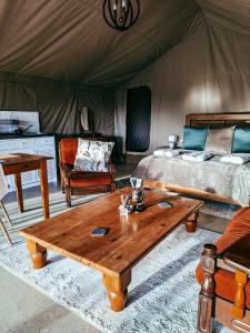una camera con letto e tavolo in legno in una tenda. di Aloeron at Patatsfontein Stay a Montagu
