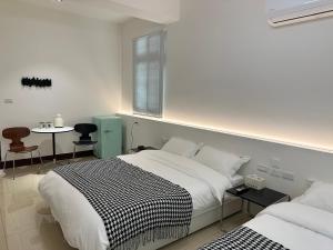 a bedroom with two beds and a table with chairs at 金門且停民宿 可包棟 好停車 近市區 in Jinning