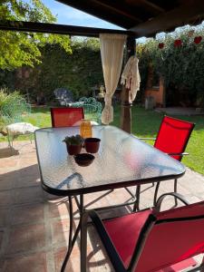 a glass table and chairs on a patio at Ama respira y vive in Salta