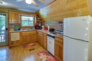 cocina con armarios de madera y nevera blanca en Dog-Friendly Home Rental about 5 Mi to Cave Run Lake! en Wellington