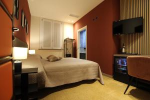 a bedroom with a bed and a flat screen tv at Le Maginot Relais in Castelvetro Piacentino