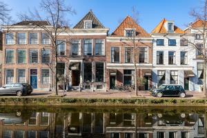 une rangée de bâtiments à côté d'une masse d'eau dans l'établissement Hotel Royal Bridges, à Delft