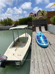 a small boat is tied to a dock at Lagoon Lounge - Waterfront villa with private pool in Kralendijk