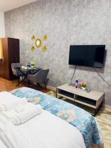 a bedroom with a bed and a flat screen tv at Cozy Apartment in Jumeirah Village Circle, Dubai. in Dubai
