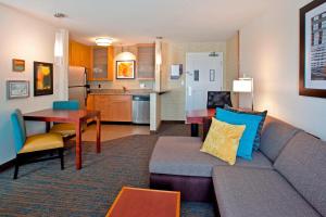 a living room with a couch and a table and a kitchen at Residence Inn by Marriott Portland Airport at Cascade Station in Portland
