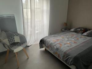 ein Schlafzimmer mit einem Bett, einem Stuhl und einem Fenster in der Unterkunft Le Lys in Lassay