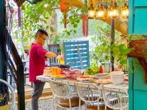 a man is preparing food at a table with a buffet at Gió Homestay in Xuan An