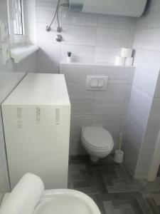 uma casa de banho branca com um WC e um lavatório em Sunrise- apartmani uz more em Betina