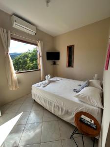 a bedroom with a large bed and a window at Pôr do Sol Suítes in Lençóis