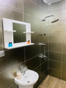 uma casa de banho com um lavatório e um chuveiro com um espelho. em deperlas em Atakum