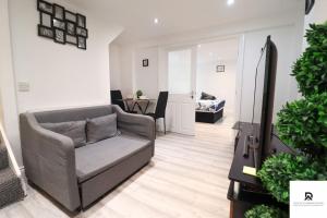 a living room with a couch and a table at Den Accommodation & Short Lets Greenwich London - 3 Bed House in London