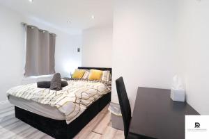a bedroom with a large bed and a table at Den Accommodation & Short Lets Greenwich London - 3 Bed House in London