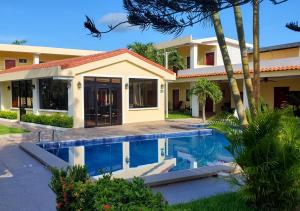 une maison avec une piscine en face de celle-ci dans l'établissement Hotel y Restaurante Maria Ofelia, à San Luis