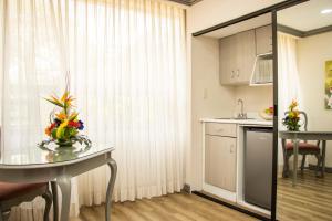 a kitchen with a table with a vase of flowers on it at Hotel Santander Plaza in Guatemala