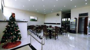 a christmas tree in a restaurant with a dining room at Poupahotel Faria Lima in Taubaté