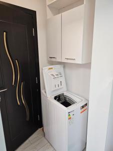 een wasmachine en droger in een keuken naast een deur bij APARTAMENT 9 RO&MARIO Barlad in Bîrlad