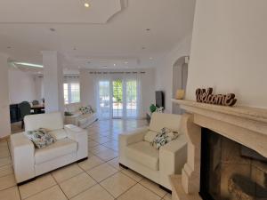 a living room with two chairs and a fireplace at Villa Monte Branco in São Bartolomeu de Messines