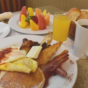 two plates of breakfast food on a table with juice at Hilton Garden Inn Guatemala City in Guatemala