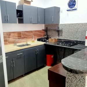 a kitchen with gray cabinets and a sink and a counter at Villa Dream in Luxor