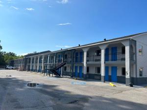 um edifício de apartamentos com portas azuis e um parque de estacionamento em Blue Star inn em Lafayette