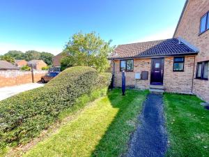 a house with a hedge next to a building at Escape to Tranquil 1 bed, Poole in Canford Magna