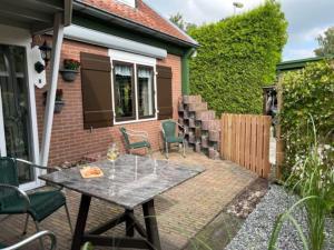 une terrasse avec une table et des chaises devant une maison dans l'établissement Huisje Marie Loosdrecht, à Loosdrecht