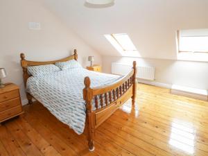 1 dormitorio con 1 cama y suelo de madera en Aisling, en Foxford