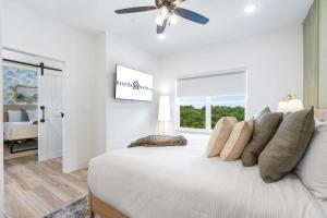 a white bedroom with a bed with a ceiling fan at Panoramic Lake Views, Free Silver Dollar City Tickets, Stunning Decor in Kimberling City +112 photos