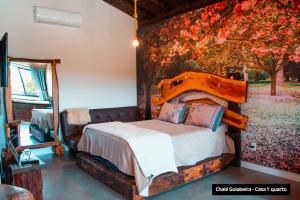 - une chambre avec un lit orné d'une peinture murale dans l'établissement Recanto Vera Lucia, à Santo Amaro da Imperatriz