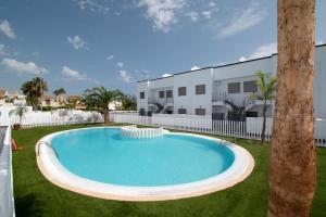 a large swimming pool in a yard next to a building at Torrebeach in Torre de la Horadada