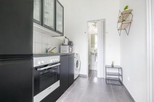 维也纳Inviting Economy 1BR Apt. with the best Location的黑白厨房配有洗衣机和烘干机