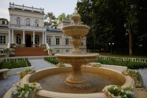 une grande fontaine en face d'une demeure de caractère dans l'établissement Pałac Chojnata, à Wola Chojnata