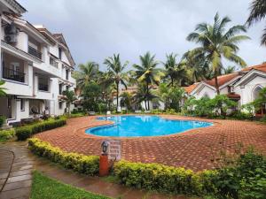 a swimming pool in the middle of a resort at Riviera Hermitage Goa in Arpora