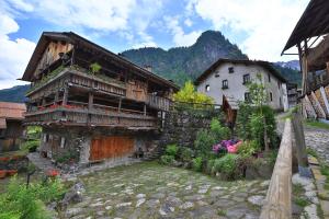 stary budynek z kwiatami przed nim w obiekcie Alpenhotel La Montanara w mieście Rocca Pietore