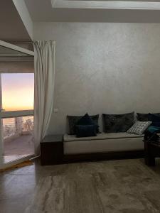 un sofá en una sala de estar con ventana en Beautiful apartment with SEAVIEW Malabata, en Tánger