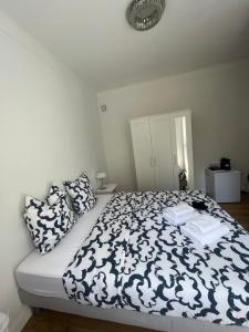 a bedroom with a bed with a black and white comforter at Chambre de charme n5 in Grimaud
