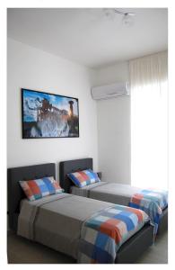 Un dormitorio con dos camas y un televisor en la pared. en M7 Suites Central, en Salerno