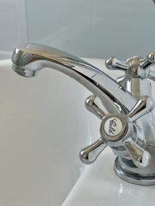 a chrome faucet on a bathroom sink at Liverpool Ivy House - 4 Bedrooms in Liverpool