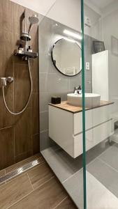 een badkamer met een wastafel en een spiegel bij Linden Apartman 107 - Adults Only in Mosonmagyaróvár