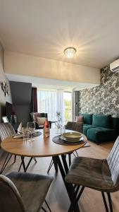 uma sala de estar com uma mesa e um sofá verde em Linden Apartman 107 - Adults Only em Mosonmagyaróvár