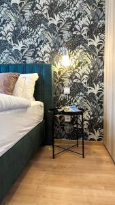 um quarto com uma cama e uma mesa com papel de parede em Linden Apartman 107 - Adults Only em Mosonmagyaróvár