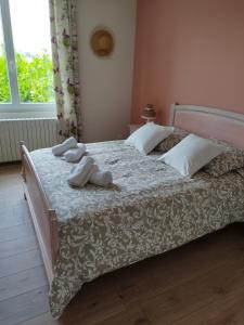 a bedroom with a bed with two slippers on it at Les Ecureuils 4 / 6 personnes in Seigy