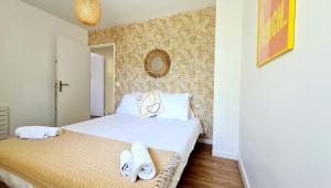 1 dormitorio con 1 cama con toallas en Happy Stay Disney Two - Apartment with garden & parking, en Montévrain