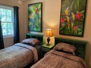 a bedroom with two beds and a painting on the wall at Belize Budget Suites in San Pedro