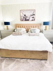 a bedroom with a large white bed with two lamps at Kenavara House in Oban