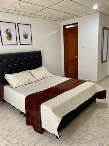 a bedroom with a large bed with a black headboard at Apartamento pinares Santa Rosa in Santa Rosa de Cabal