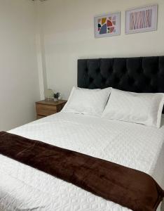 um quarto com uma cama grande e uma cabeceira preta em Apartamento pinares Santa Rosa em Santa Rosa de Cabal