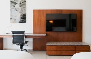 a office with a desk and a chair and a television at Fiesta Inn Playa del Carmen in Playa del Carmen