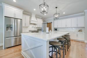 a kitchen with white cabinets and a large island with bar stools at North Carolina Home about 2 Mi to Pinehurst Resort in Pinehurst